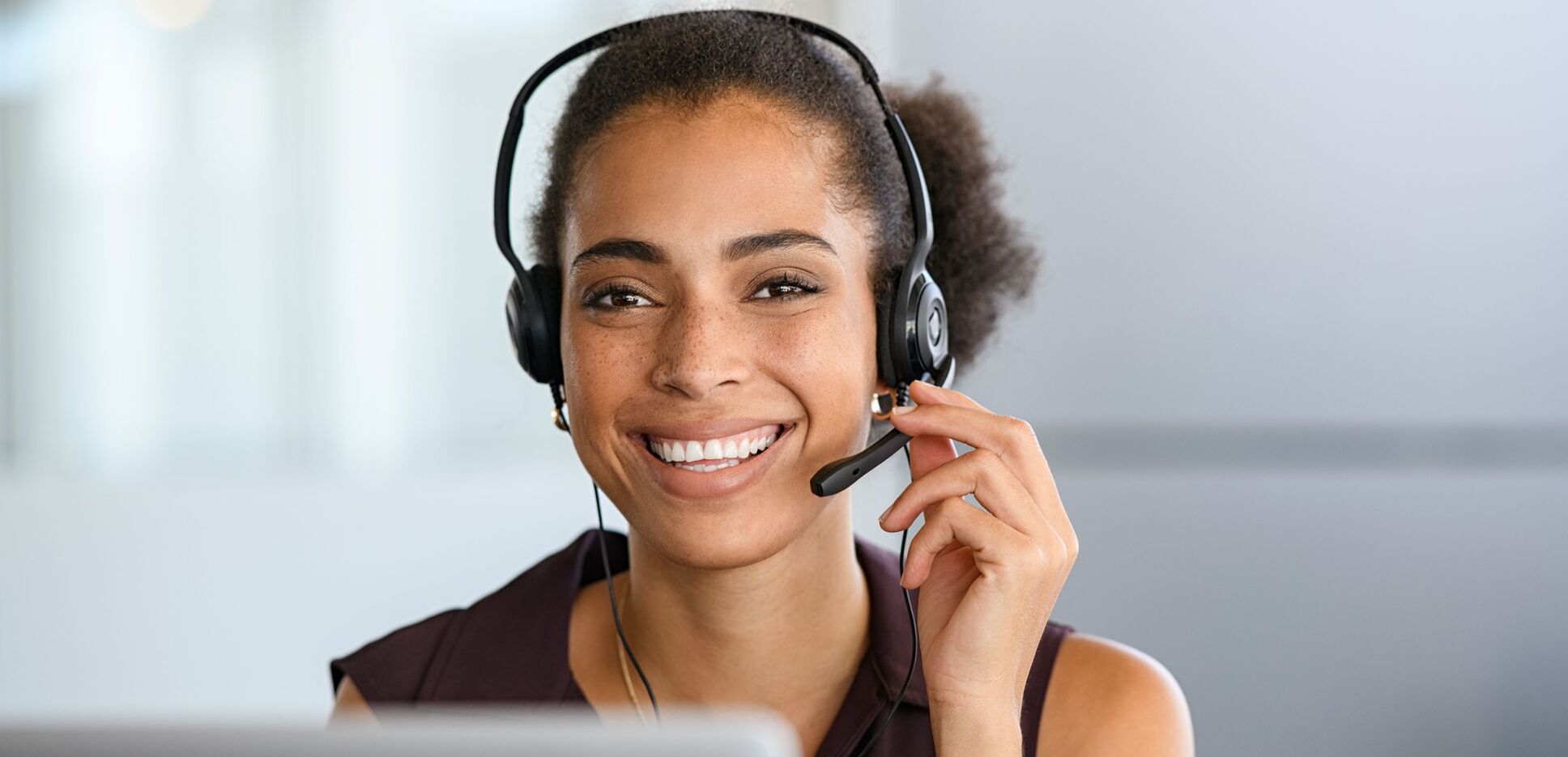 Foto einer Mitarbeiterin mit Headset im Telefonservice